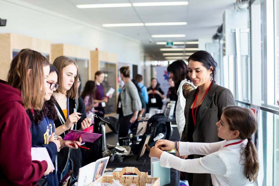 Girls interviewing a booth member at the Soroptimist Dream it Be it event